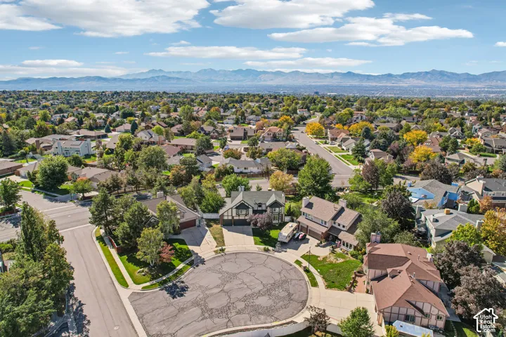 Expansive residential area featuring established homes, mature trees, and mountainous scenery