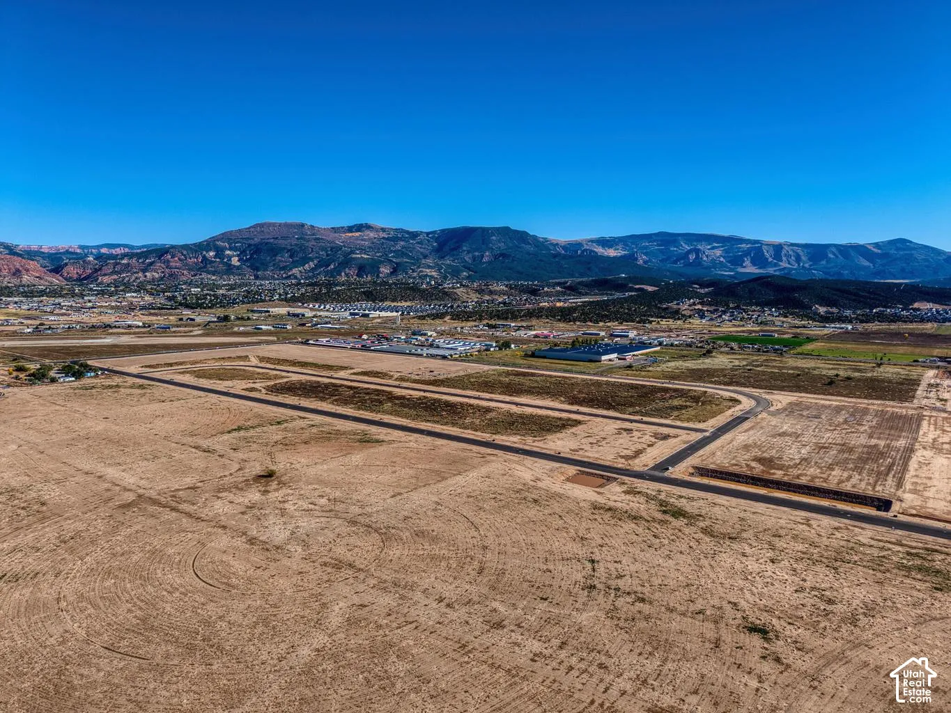 Expansive land parcel with existing roadways and a distant mountainous backdrop