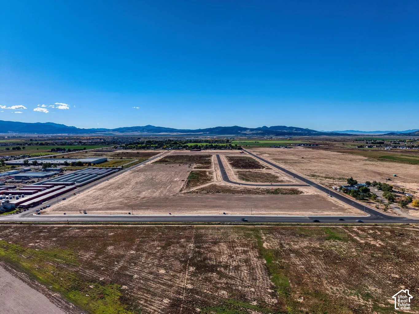 Expansive undeveloped land featuring established road infrastructure and clear mountain backdrop