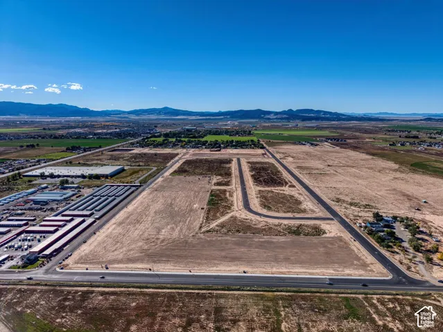 Expansive undeveloped land featuring established roadways, clear parcel demarcation, and distant mountain scenery