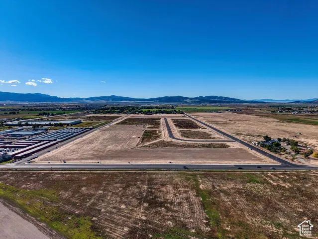 Expansive undeveloped land featuring established road infrastructure and clear mountain backdrop