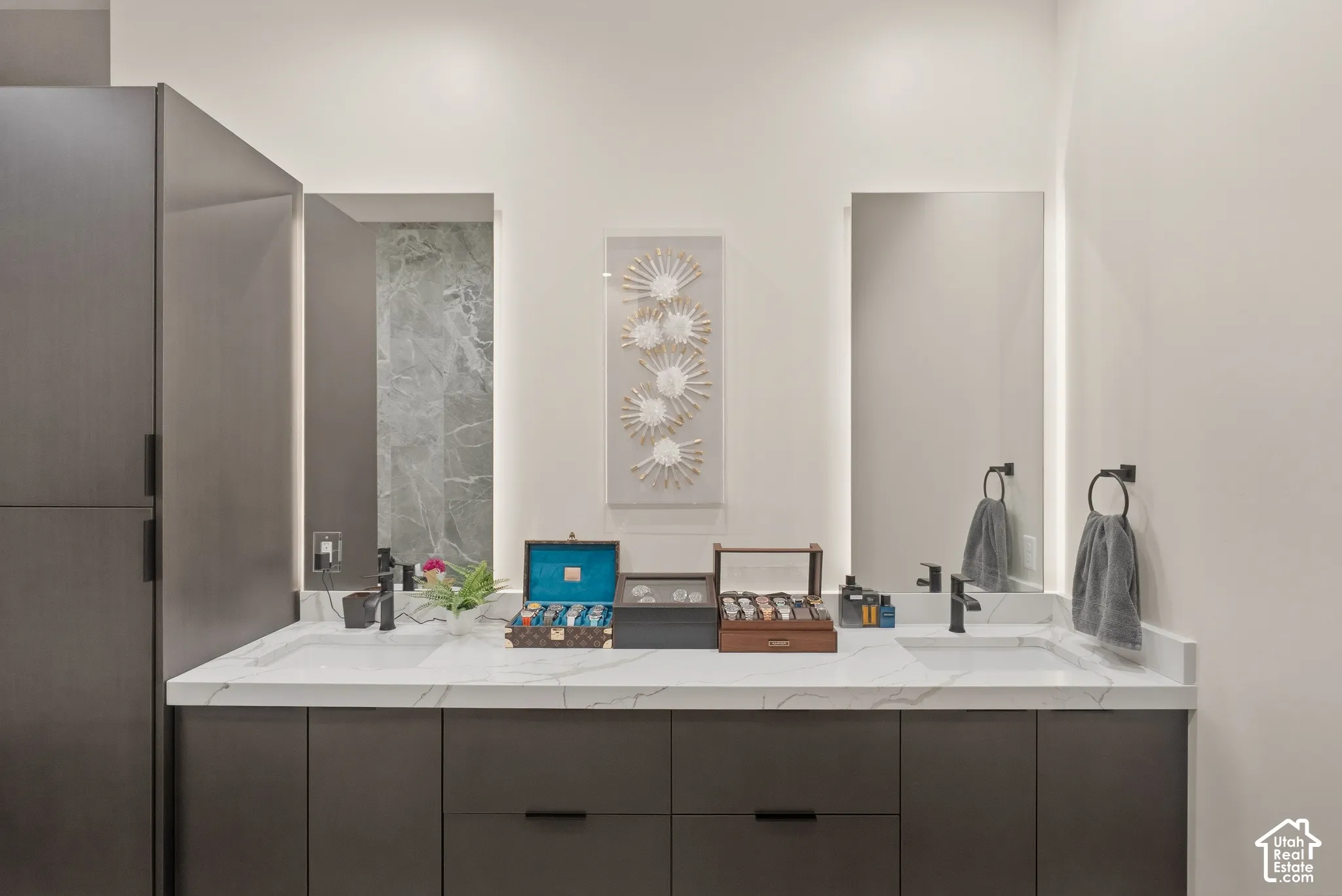 Dual vanity with integrated sinks, a white stone-finish countertop, and dark wood-finish cabinetry
