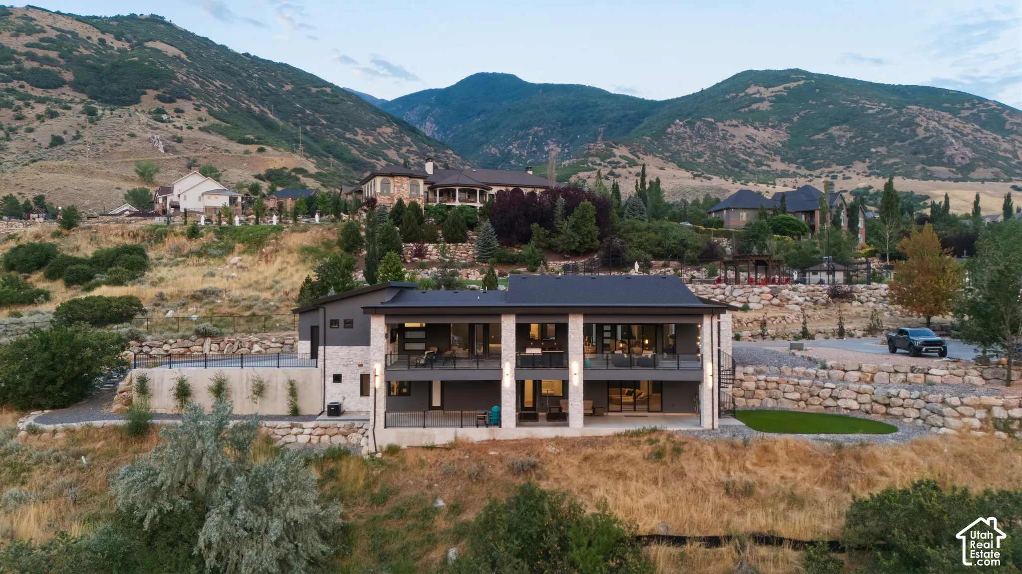 Contemporary multi-level residence featuring expansive window walls, multiple balconies with black railings, and a flat roofline
