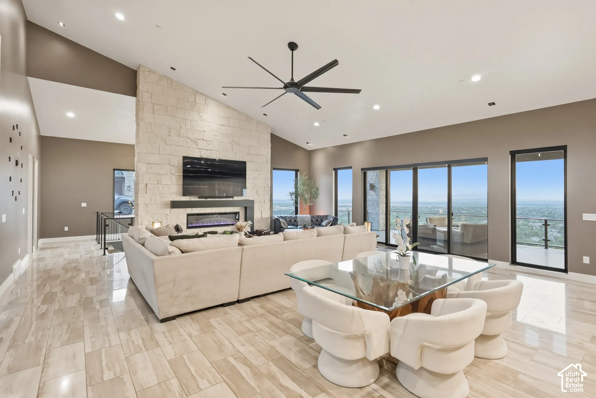 Spacious interior with vaulted ceilings, a stone accent wall, recessed lighting, and large sliding glass doors