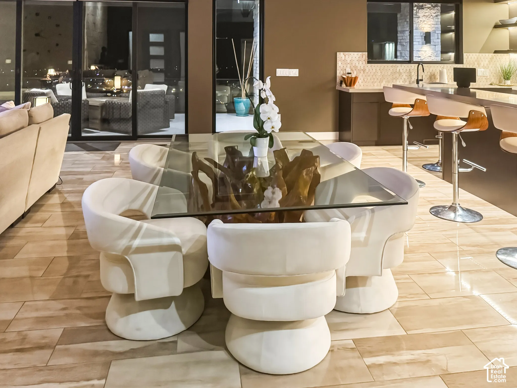 Full-height sliding glass doors, built-in bar seating, tile flooring, and a stone-clad accent wall