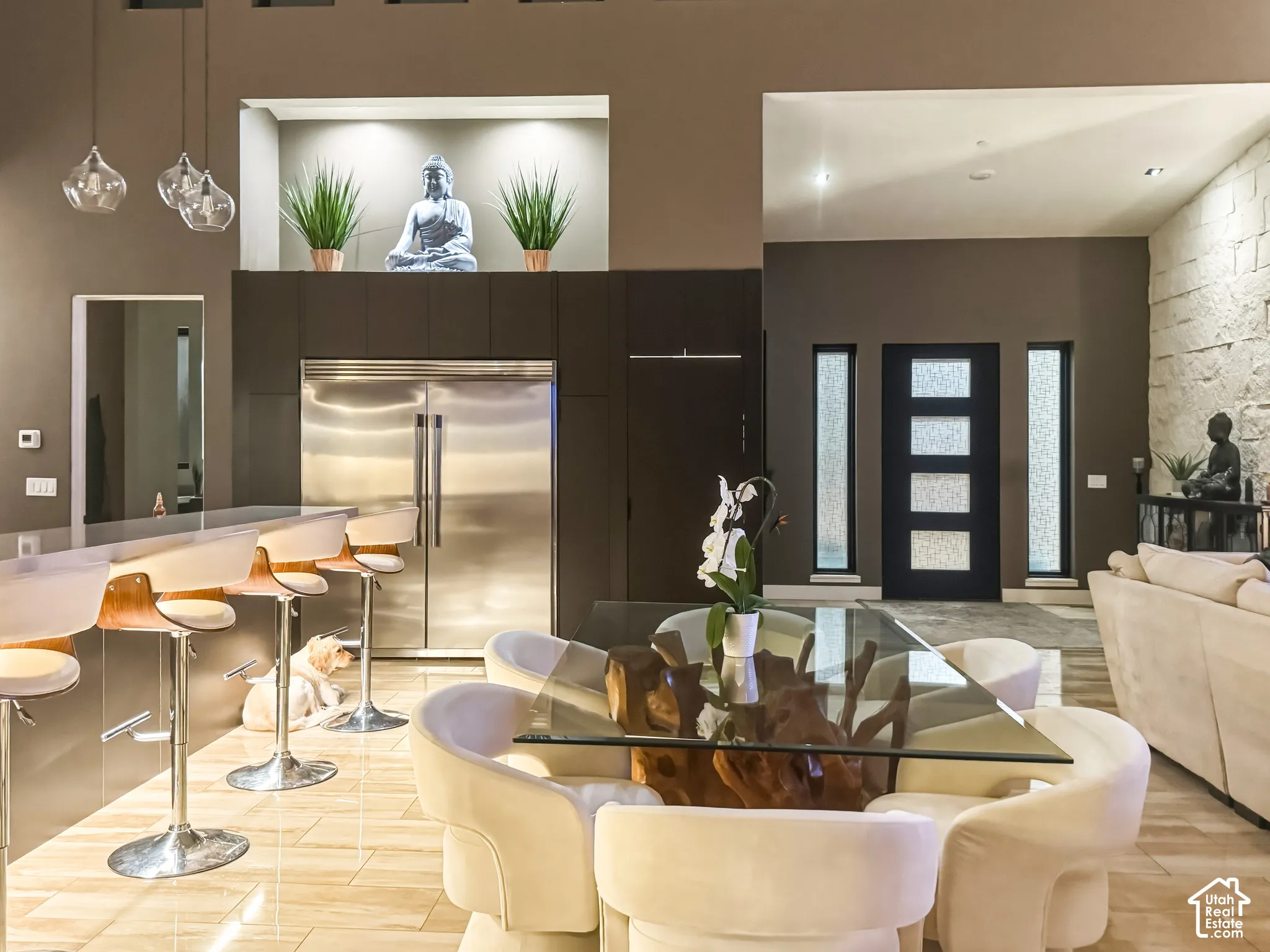 Stainless steel refrigerator, built-in cabinetry, modern entry door with vertical windows, and a textured accent wall