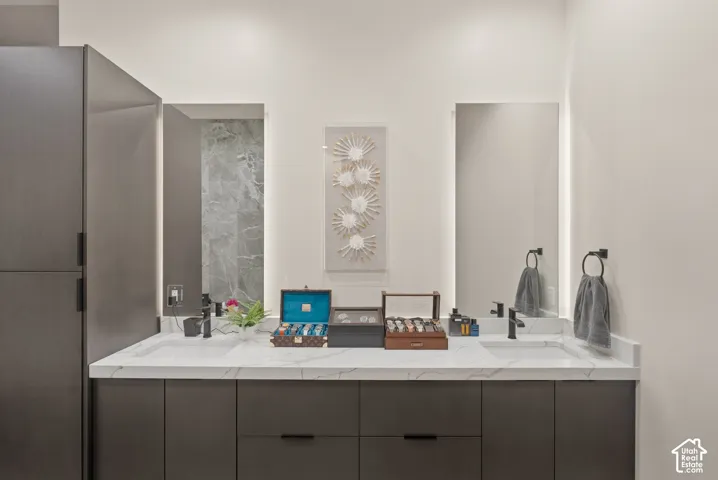Dual vanity with integrated sinks, a white stone-finish countertop, and dark wood-finish cabinetry