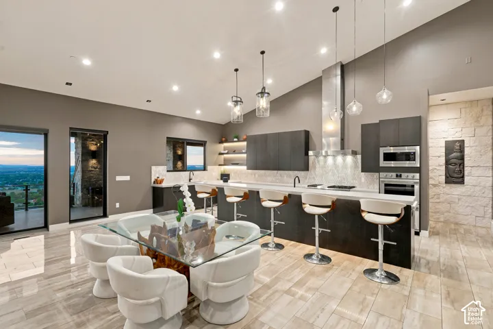 Contemporary kitchen featuring dark wood-finish cabinetry, stainless steel appliances, and an expansive island with bar seating