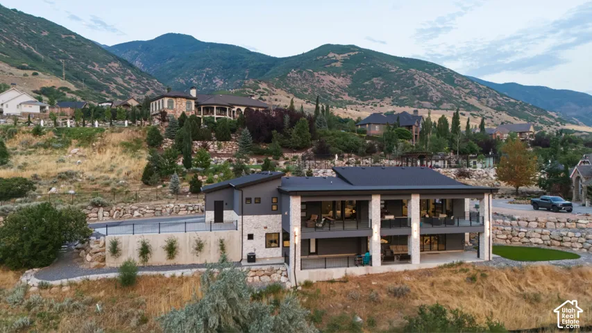 Modern exterior with stone and paneling accents, multiple levels of outdoor living space, and a flat roofline