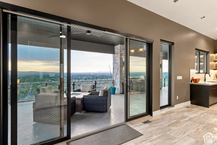 Expansive sliding glass doors, a stone accent column, recessed ceiling lighting, and wood-finish flooring