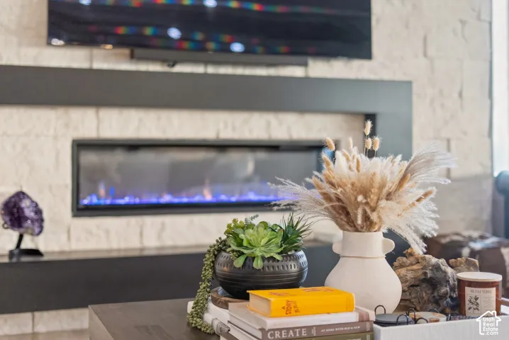 Stacked stone fireplace surround with an elongated electric fireplace and a wall-mounted media console