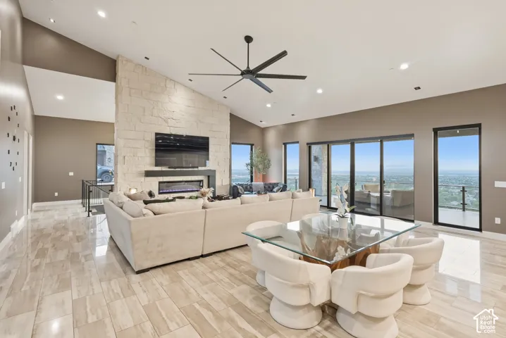Spacious interior with vaulted ceilings, a stone accent wall, recessed lighting, and large sliding glass doors