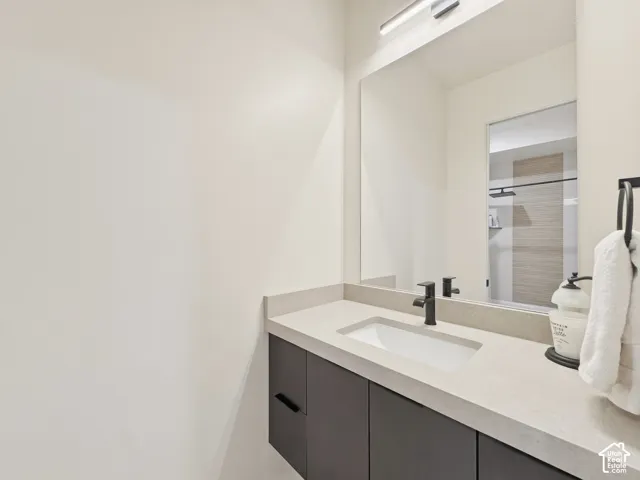 Floating vanity with a light-toned countertop, integrated sink, and matte black faucet