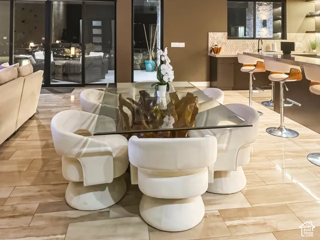 Full-height sliding glass doors, built-in bar seating, tile flooring, and a stone-clad accent wall