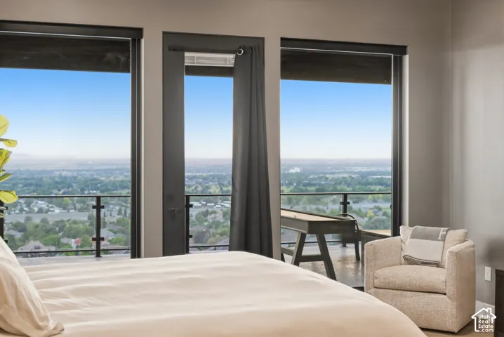 Expansive balcony with black metal and glass railing system, accessed by a glass-paneled door