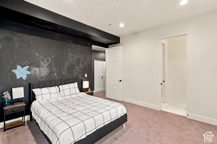 Recessed lighting, a dark accent wall, plush carpeting, and a five-panel interior door