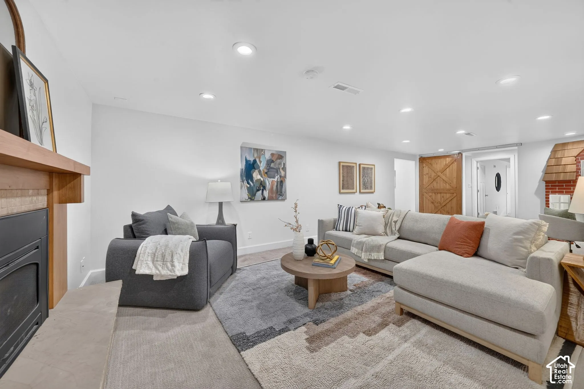 Lower family room with a gas fireplace, sliding barn door, and the built-in playhouse.