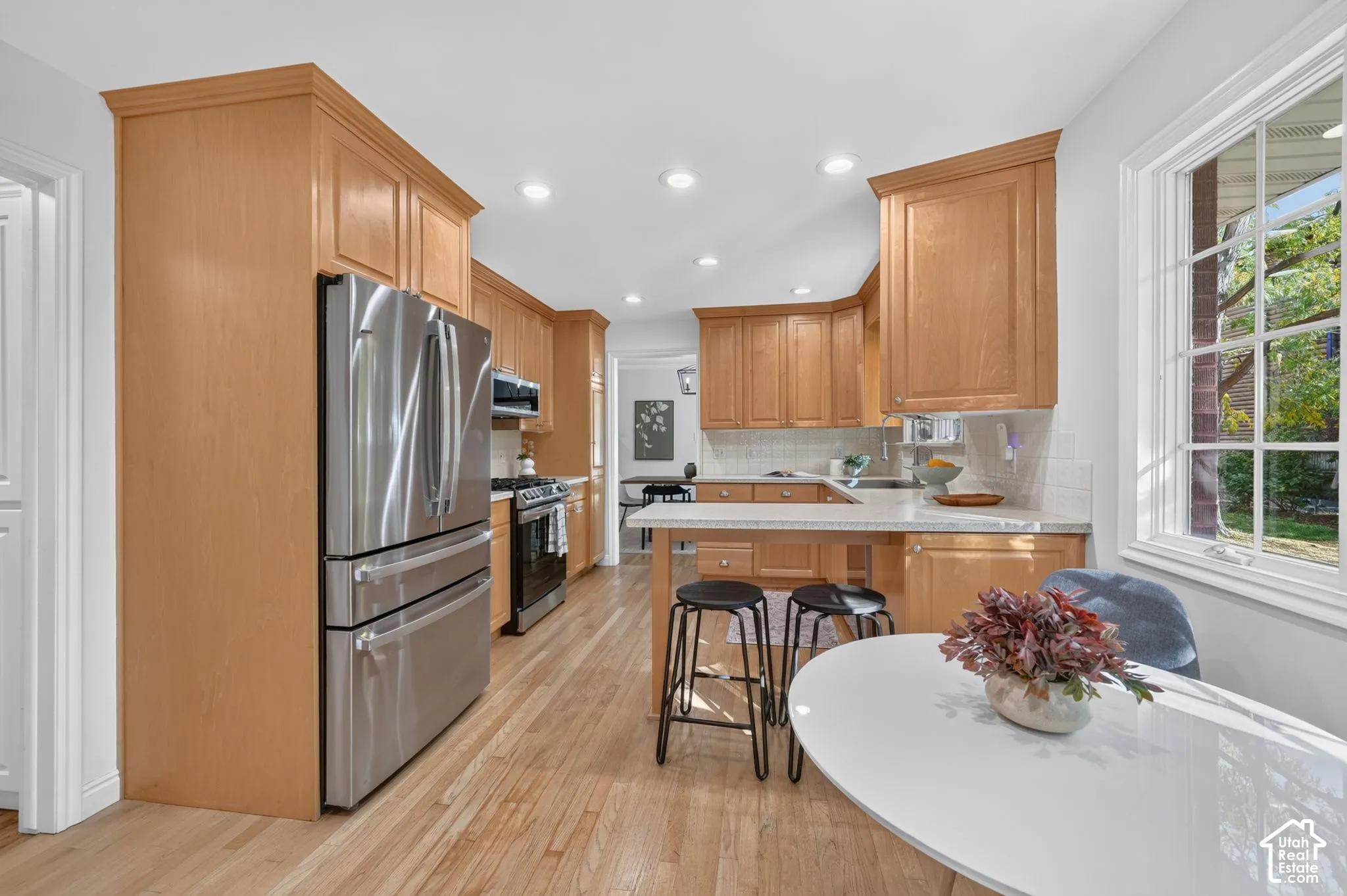 Updated kitchen with wood cabinets, stainless appliances, and bar seating.