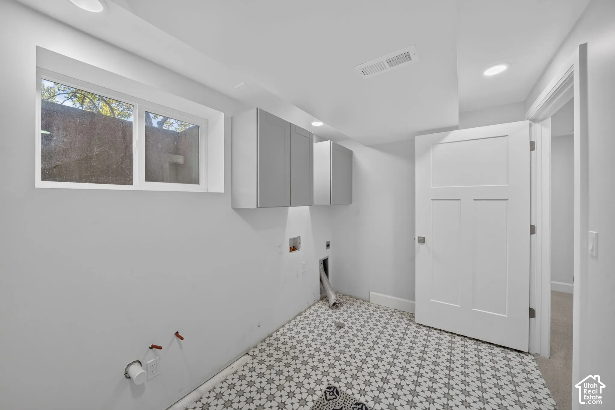 Gas and electric dryer hookups with storage.