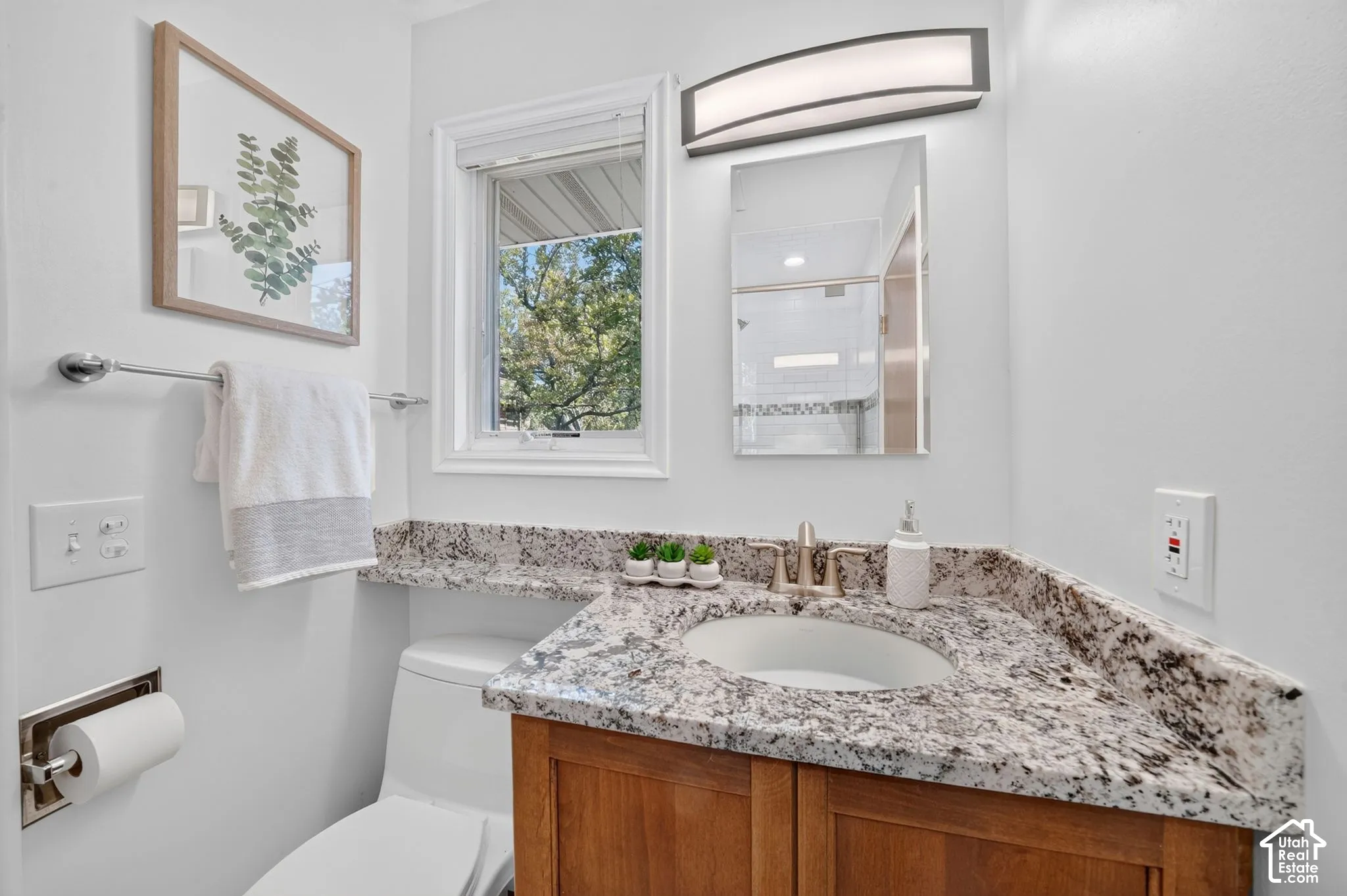 Primary ensuite bath with a granite vanity and a tiled shower.