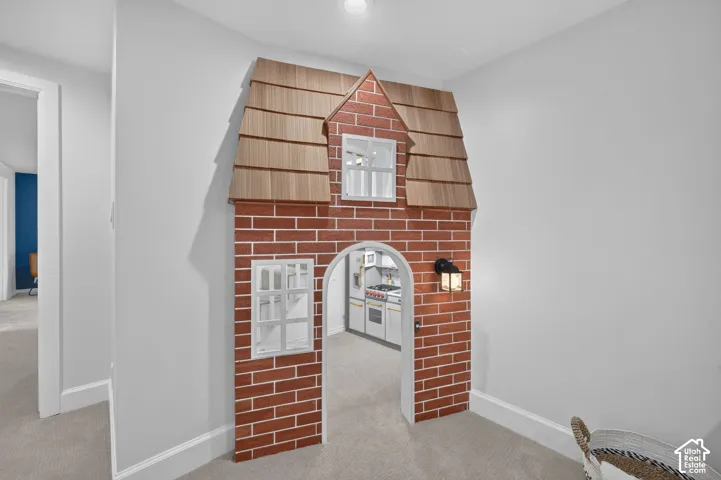 Built-in playhouse with a cottage facade and play kitchen in the lower level.