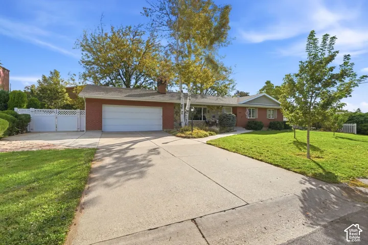 Wide concrete driveway, attached two-car garage, RV parking, and an EV charging station.