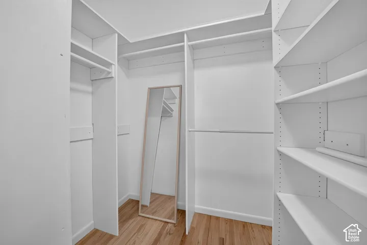 Primary bedroom's walk-in closet with built-in shelving and hanging space.
