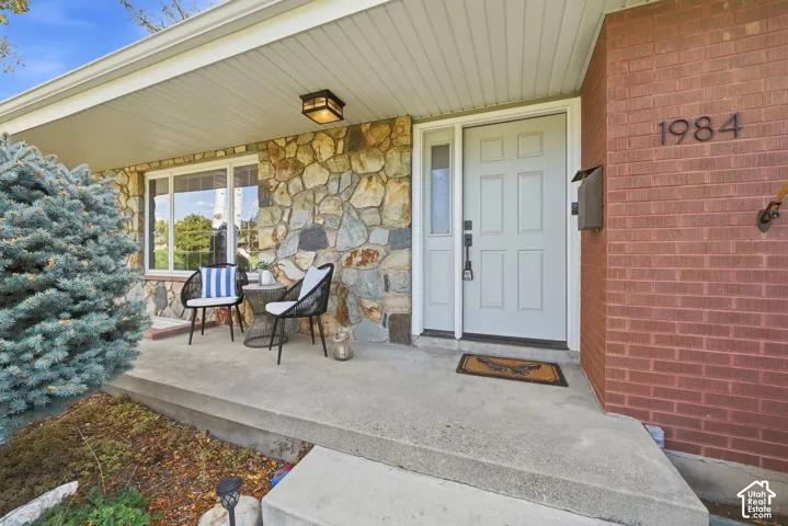Covered stone-and-brick entry with room for a sitting area.