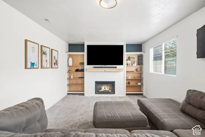 Built-in shelving flanking a central fireplace with a light wood mantle