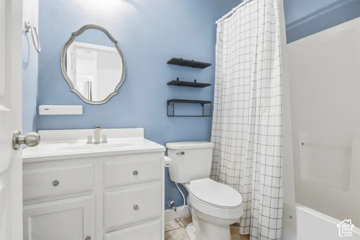 White vanity with integrated sink, brushed nickel faucet, and decorative mirror