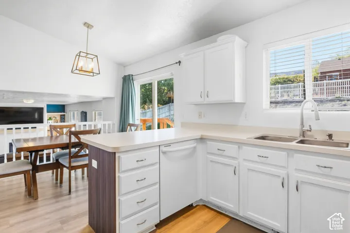 White shaker-style cabinetry with chrome hardware, light-toned countertops, and dual stainless steel sink