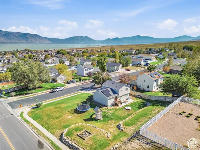 Residential property with an expansive green lawn, featuring a fire pit area and a paved street