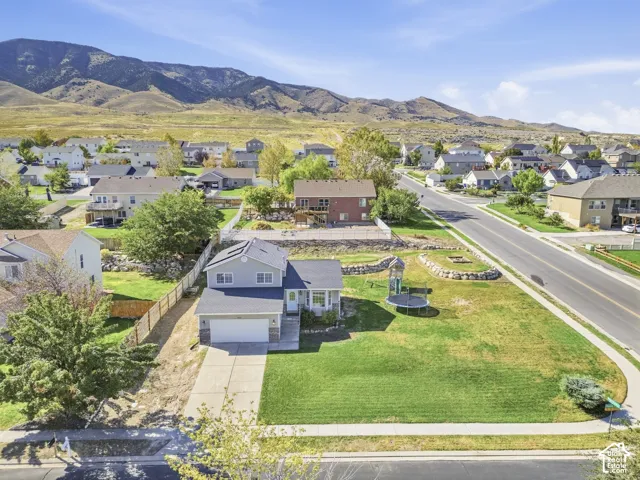 Two-story residence featuring a front-facing garage, concrete driveway, and expansive front lawn
