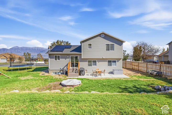 Expansive backyard featuring a manicured lawn, a concrete patio, and a privacy fence