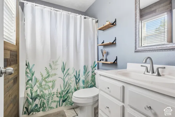 White vanity with a single basin sink and brushed nickel faucet