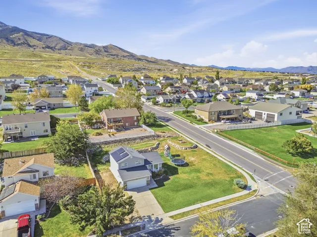Residential neighborhood with paved streets and sidewalks, surrounded by distant mountains