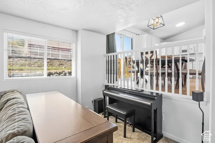 White painted baluster railing, recessed lighting, window with horizontal blinds, wood-finish flooring, and a contemporary ceiling light fixture