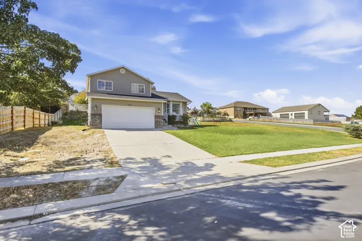 Two-story residence featuring a two-car garage, stone accents, and a concrete driveway