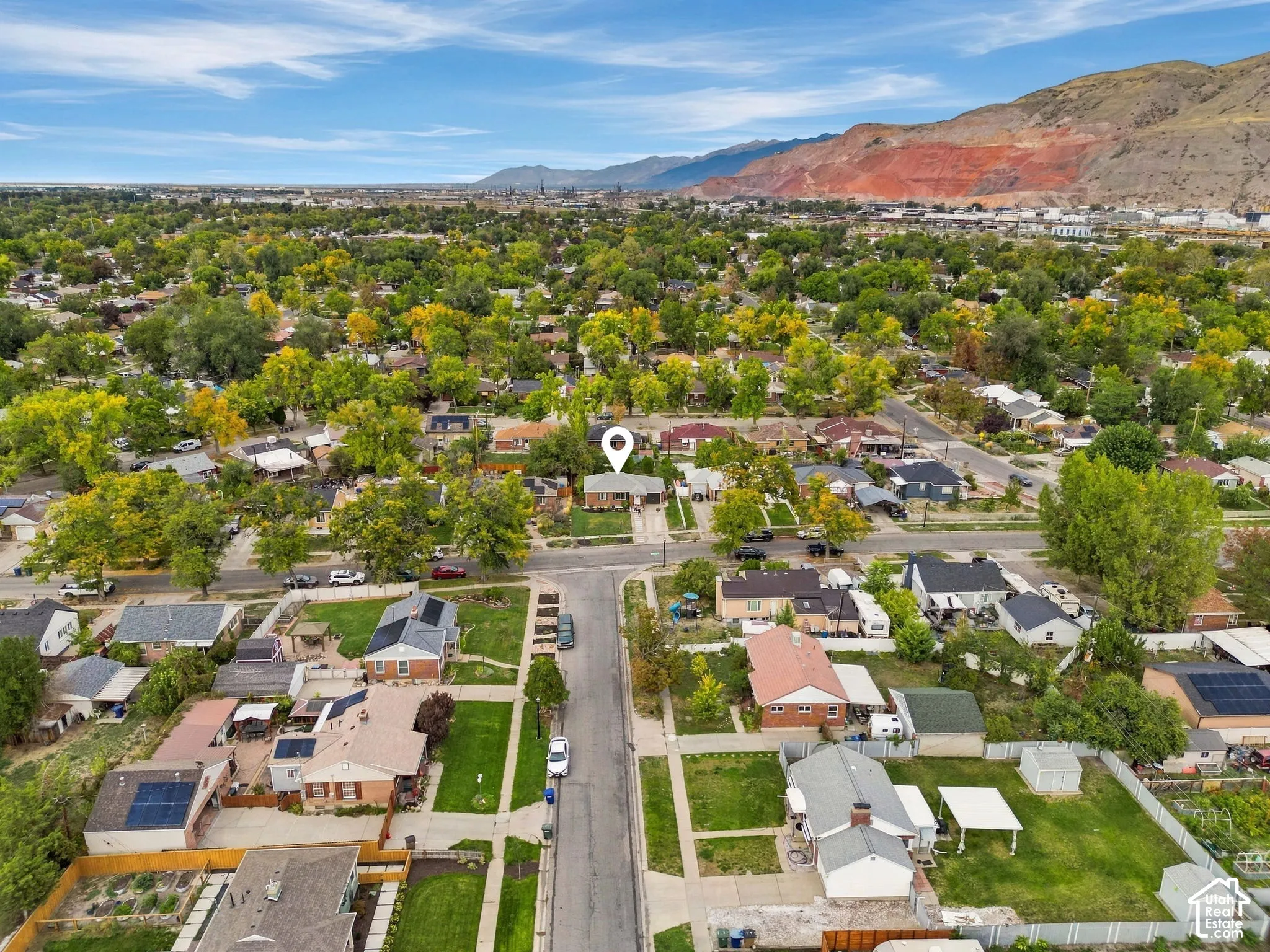 Residential street with mature trees and mountain backdrop