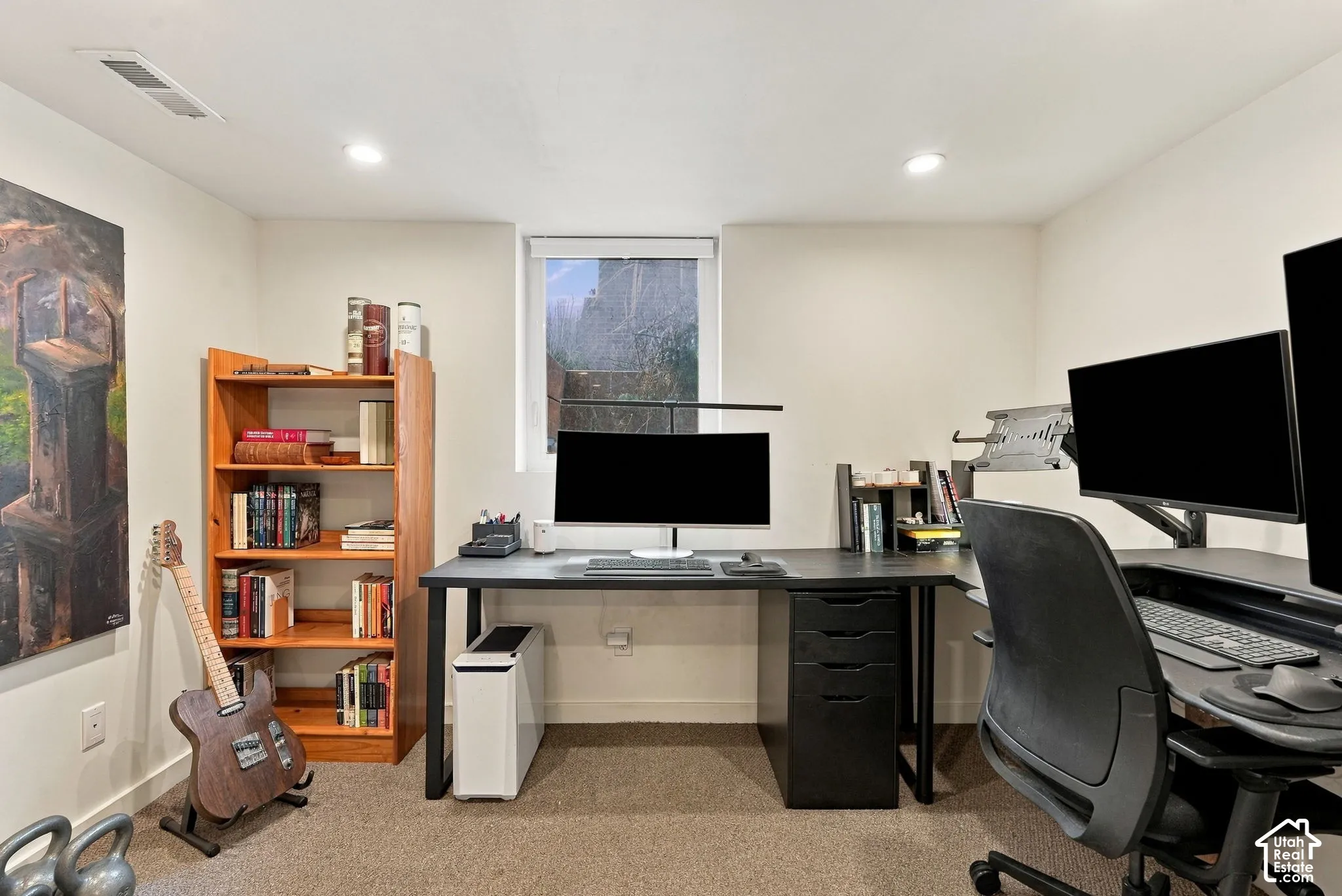 Recessed lighting, light-colored walls, and a window provide illumination