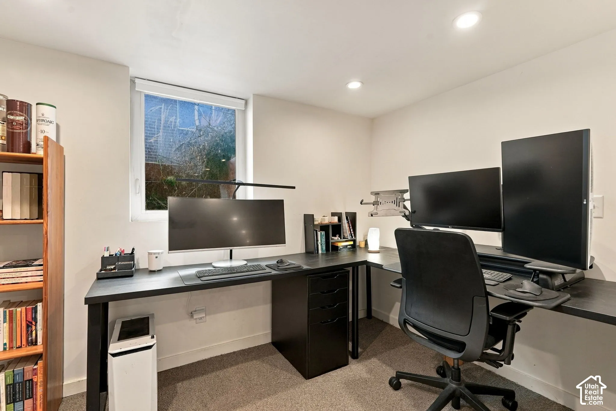 Recessed ceiling lighting, a window with roller shade, and light gray wall paint
