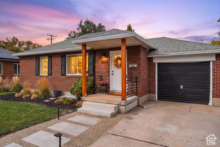 Brick exterior with a covered porch entry, a single-car garage, and a concrete paver walkway