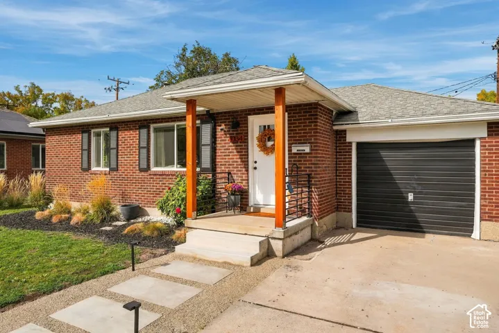 Brick exterior with a single-car garage and a covered porch entry