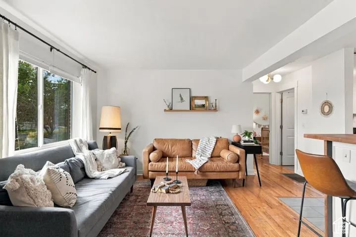Hardwood flooring, abundant natural light, recessed lighting, white walls, and a built-in shelving unit