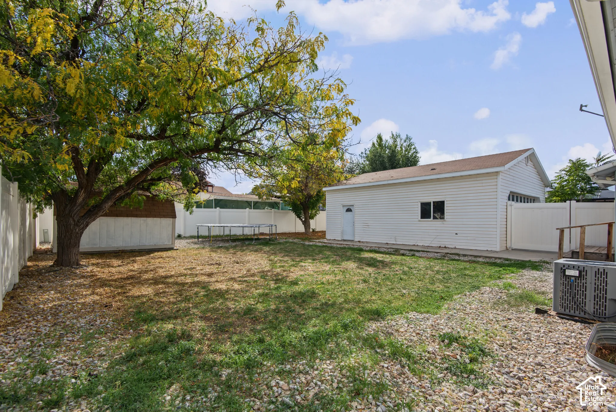 Expansive yard featuring mature trees and privacy fencing