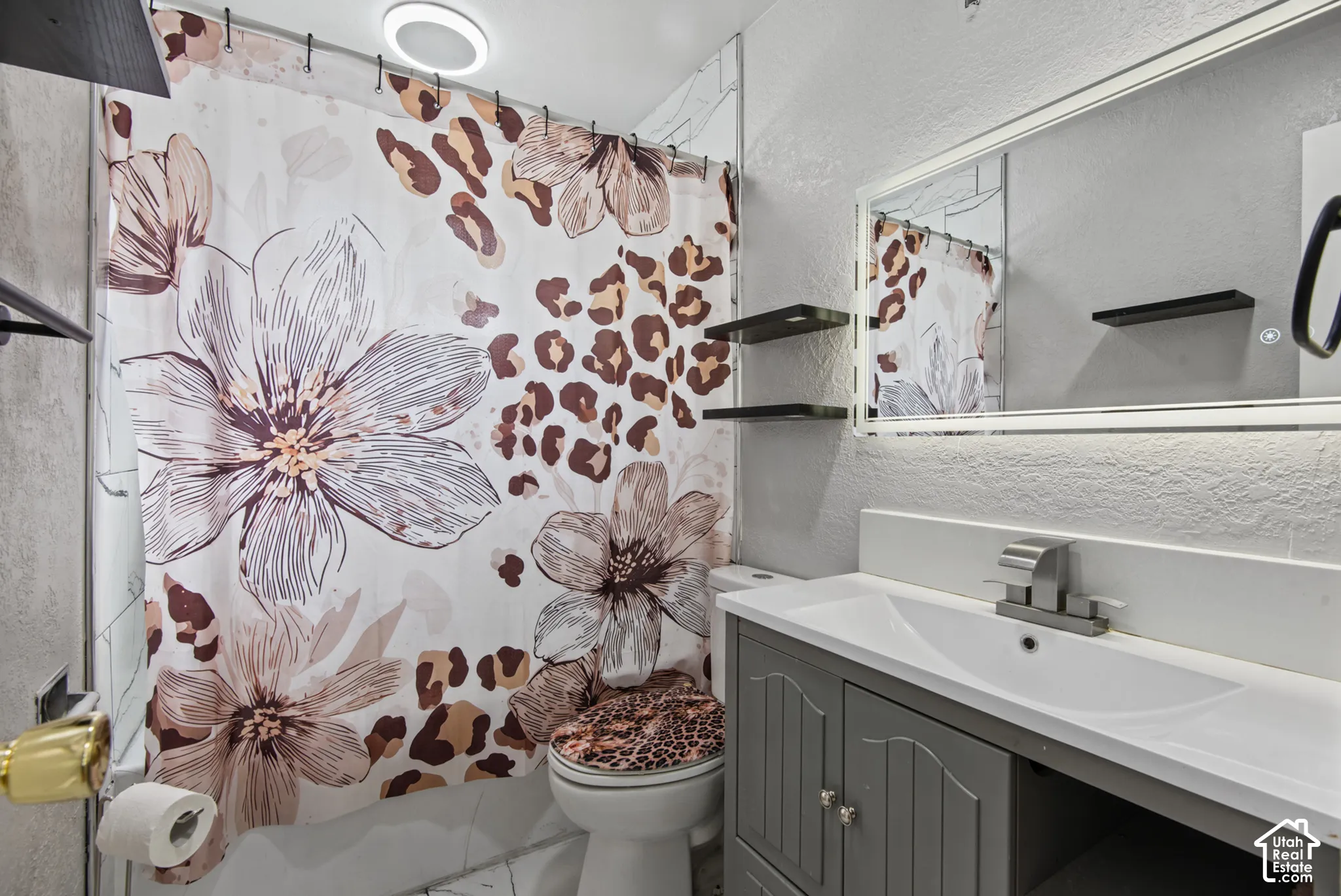 Vanity with integrated sink, wall-mounted mirror, and floating wall shelves