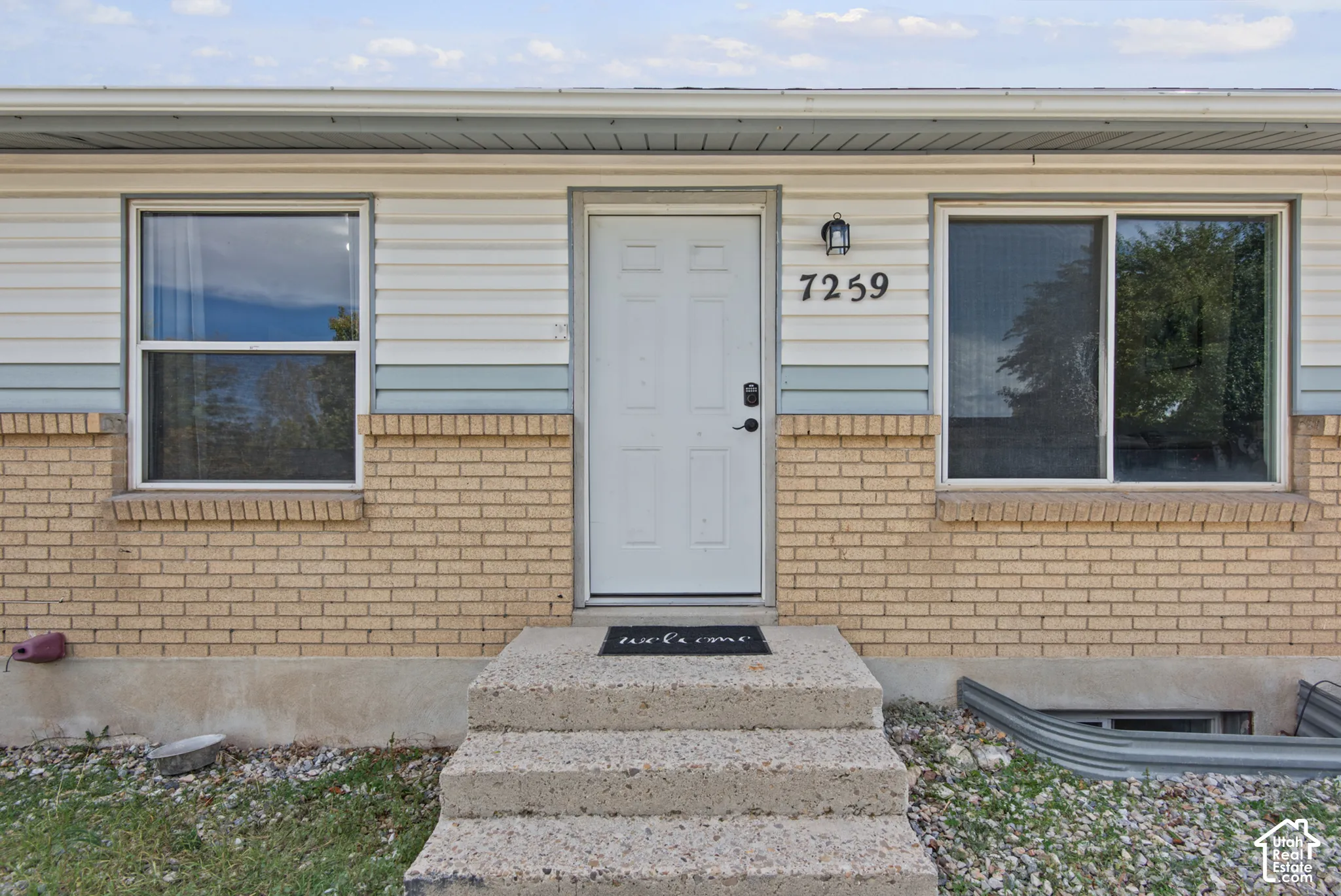 Brick and siding exterior with a concrete entryway