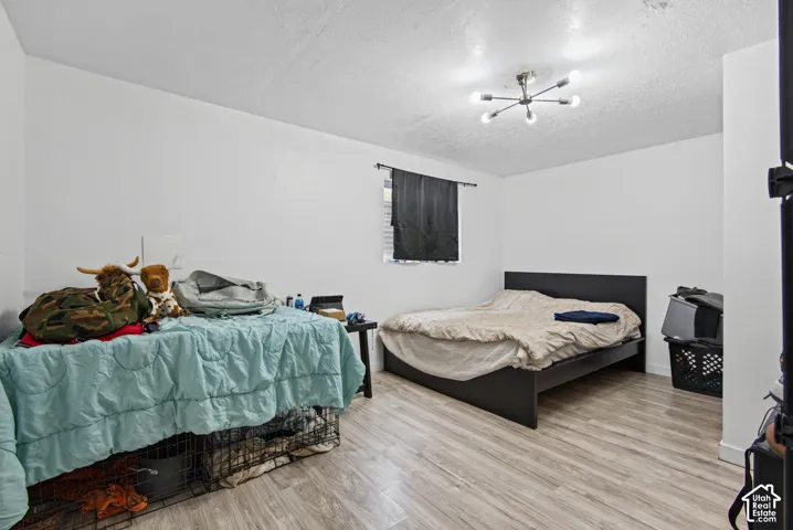 White walls, wood-finish flooring, and a modern sputnik-style ceiling light fixture