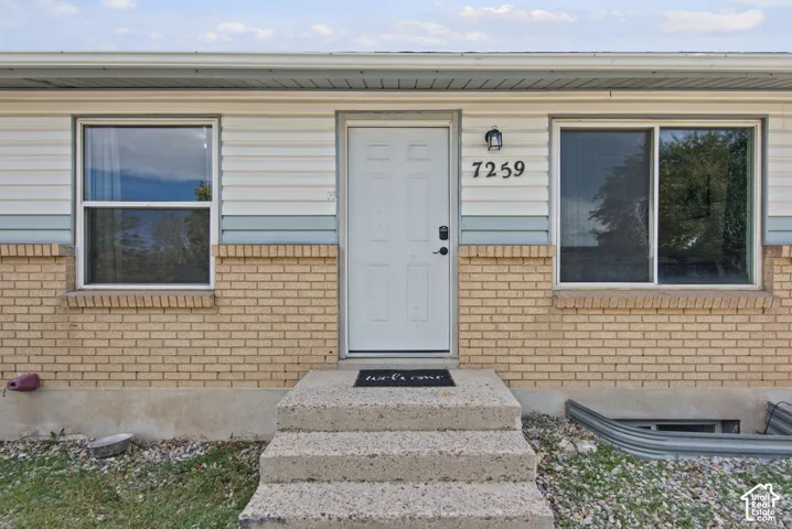 Brick and siding exterior with a concrete entryway