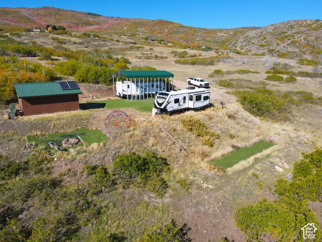 Brown shed with a green metal roof and integrated solar panels